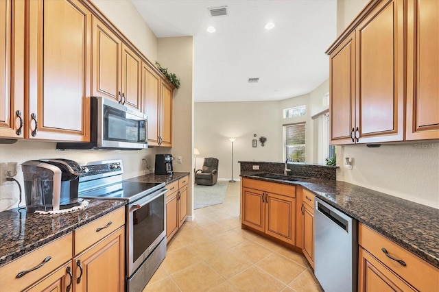 6312 41st Ct E, Sarasota, FL 34243 - kitchen featuring stainless steel appliances, light tile patterned floors, dark stone countertops, a peninsula, and recessed lighting