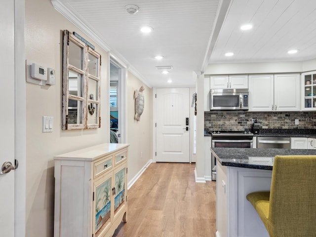 8710 Midnight Pass Rd Unit 205, Sarasota, FL 34242 - kitchen with stainless steel appliances, crown molding, light wood-style flooring, white cabinets, and glass insert cabinets
