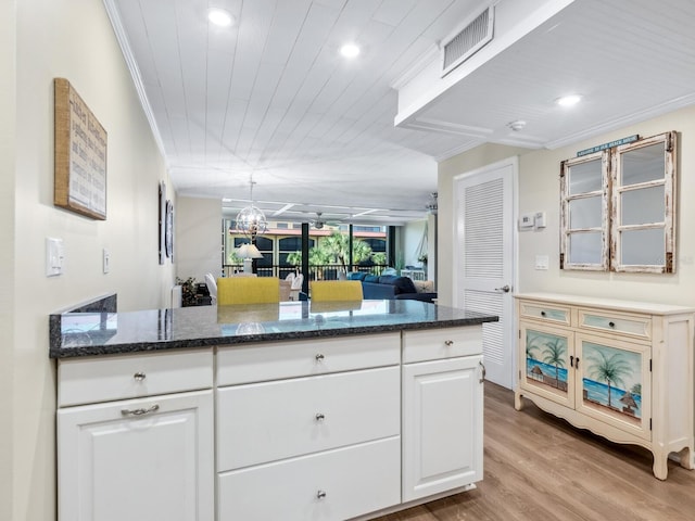 8710 Midnight Pass Rd Unit 205, Sarasota, FL 34242 - kitchen with ornamental molding, white cabinets, recessed lighting, light wood finished floors, and dark stone countertops