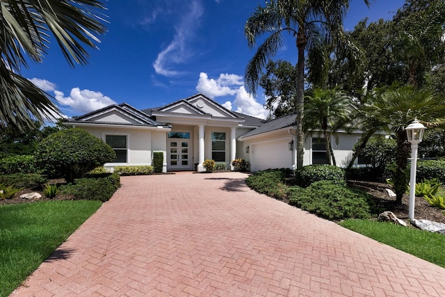 7211 Marston Ct, University Park, FL 34201 - single story home featuring a garage, french doors, stucco siding, and decorative driveway
