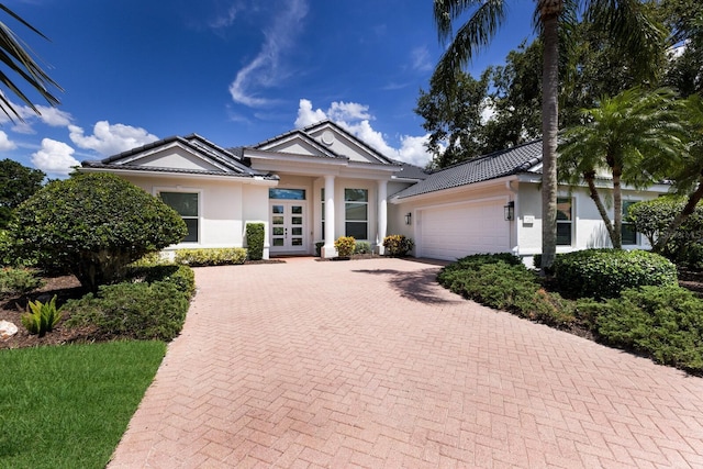 7211 Marston Ct, University Park, FL 34201 - single story home featuring stucco siding, a garage, decorative driveway, french doors, and a tiled roof