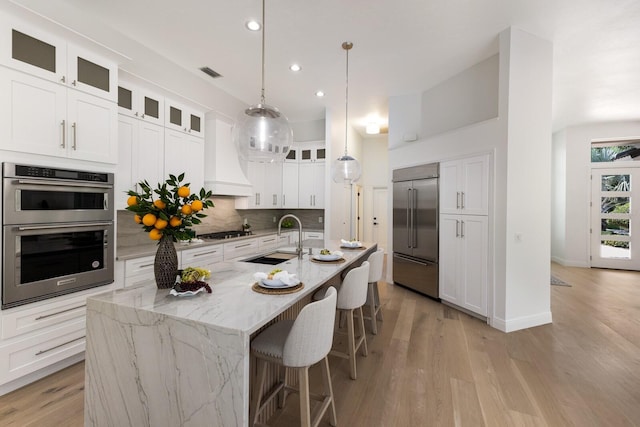 7211 Marston Ct, University Park, FL 34201 - kitchen featuring stainless steel appliances, tasteful backsplash, recessed lighting, light wood-style floors, and a breakfast bar