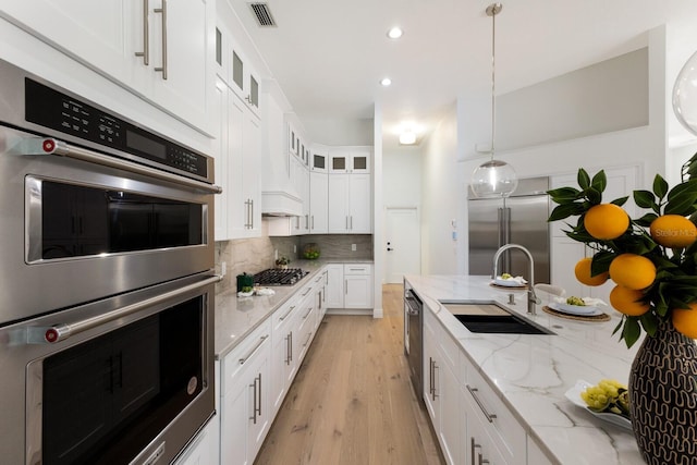 7211 Marston Ct, University Park, FL 34201 - kitchen with appliances with stainless steel finishes, decorative backsplash, light wood finished floors, white cabinets, and glass insert cabinets