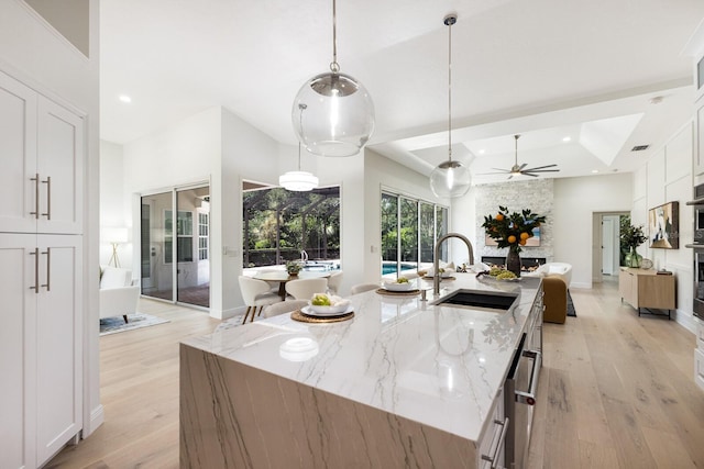 7211 Marston Ct, University Park, FL 34201 - kitchen featuring light wood-style flooring, white cabinets, a large island, a tray ceiling, and recessed lighting