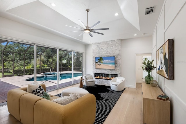 7211 Marston Ct, University Park, FL 34201 - living area with ceiling fan, a sunroom, recessed lighting, wood finished floors, and a stone fireplace
