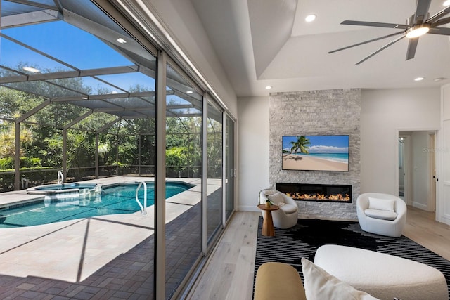7211 Marston Ct, University Park, FL 34201 - view of swimming pool featuring ceiling fan, a stone fireplace, and a pool with connected hot tub