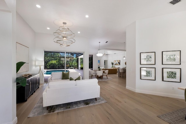 7211 Marston Ct, University Park, FL 34201 - living room with light wood finished floors, recessed lighting, and a chandelier