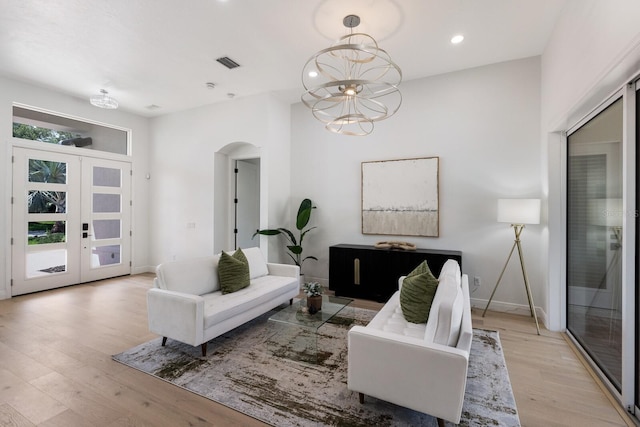 7211 Marston Ct, University Park, FL 34201 - living area with arched walkways, light wood-type flooring, french doors, a chandelier, and recessed lighting