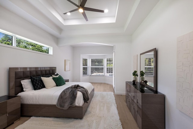 7211 Marston Ct, University Park, FL 34201 - bedroom with light wood-style flooring, a tray ceiling, arched walkways, and ceiling fan
