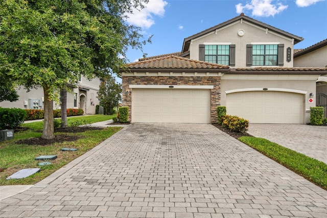 5916 Wake Forest Run Unit 101, Bradenton, FL 34211 - view of front of property with decorative driveway, stucco siding, stone siding, and a tile roof