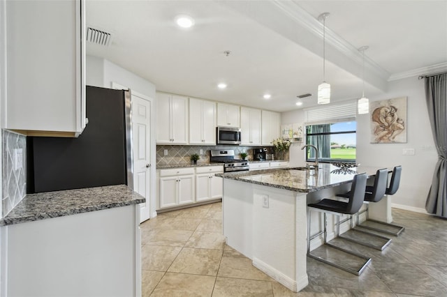 5916 Wake Forest Run Unit 101, Bradenton, FL 34211 - kitchen featuring stainless steel appliances, dark stone countertops, white cabinets, crown molding, and backsplash