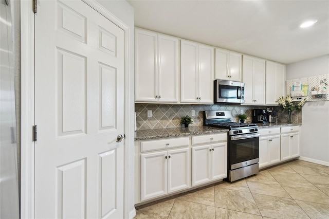 5916 Wake Forest Run Unit 101, Bradenton, FL 34211 - kitchen with appliances with stainless steel finishes, decorative backsplash, white cabinetry, and dark stone countertops