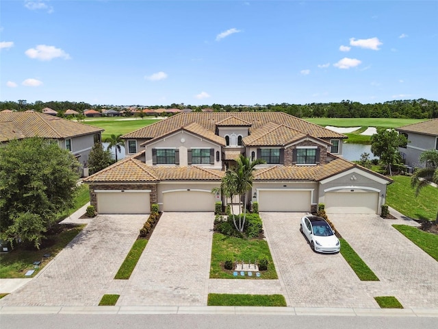 5916 Wake Forest Run Unit 101, Bradenton, FL 34211 - mediterranean / spanish home featuring a tile roof, driveway, stucco siding, and a water view