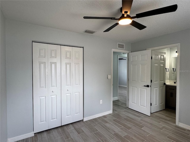 811 24th Street Ct E, Bradenton, FL 34208 - unfurnished bedroom featuring wood finished floors, a closet, ceiling fan, a textured ceiling, and ensuite bathroom