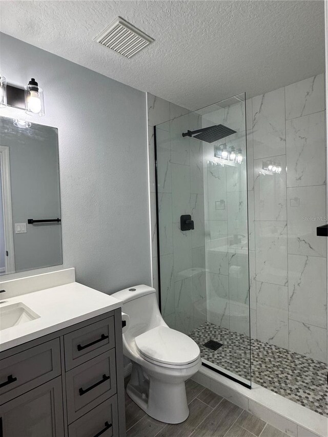 811 24th Street Ct E, Bradenton, FL 34208 - full bathroom with a textured ceiling, vanity, wood finished floors, and a marble finish shower