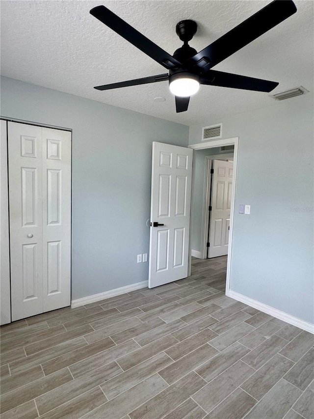 811 24th Street Ct E, Bradenton, FL 34208 - unfurnished bedroom with wood finish floors, a textured ceiling, a closet, and ceiling fan