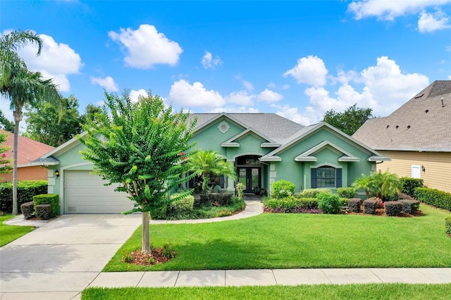 17426 Tailfeather Ct, Clermont, FL 34711 - view of front of home featuring french doors, stucco siding, driveway, a garage, and a front yard