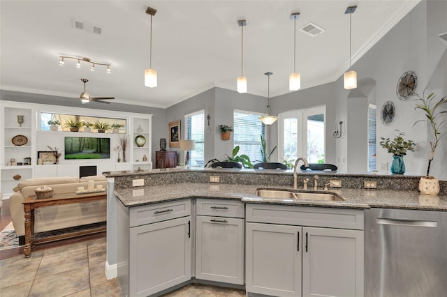 17426 Tailfeather Ct, Clermont, FL 34711 - kitchen featuring stainless steel dishwasher, open floor plan, light stone counters, ornamental molding, and hanging light fixtures