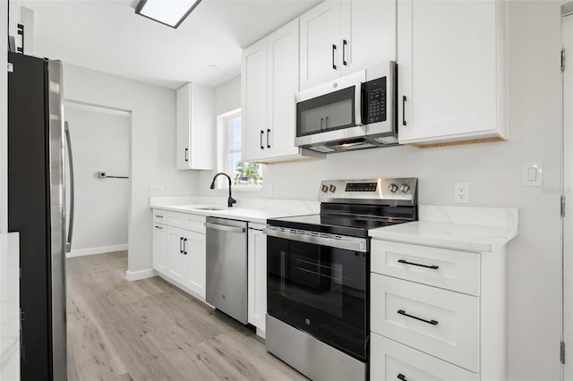 609 Carmel Rd, Venice, FL 34293 - kitchen with stainless steel appliances, light wood-type flooring, white cabinetry, and light stone counters