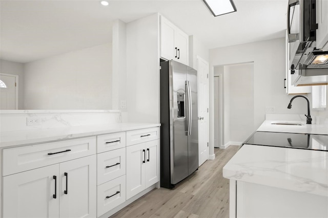 609 Carmel Rd, Venice, FL 34293 - kitchen with stainless steel fridge with ice dispenser, white cabinetry, light wood-type flooring, light stone counters, and recessed lighting