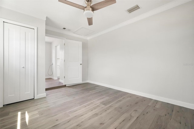 609 Carmel Rd, Venice, FL 34293 - unfurnished bedroom with wood finished floors, ornamental molding, a closet, ceiling fan, and attic access
