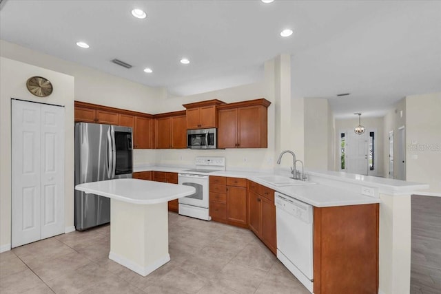 7026 43rd Ave E, Palmetto, FL 34221 - kitchen featuring appliances with stainless steel finishes, light countertops, a peninsula, brown cabinets, and recessed lighting