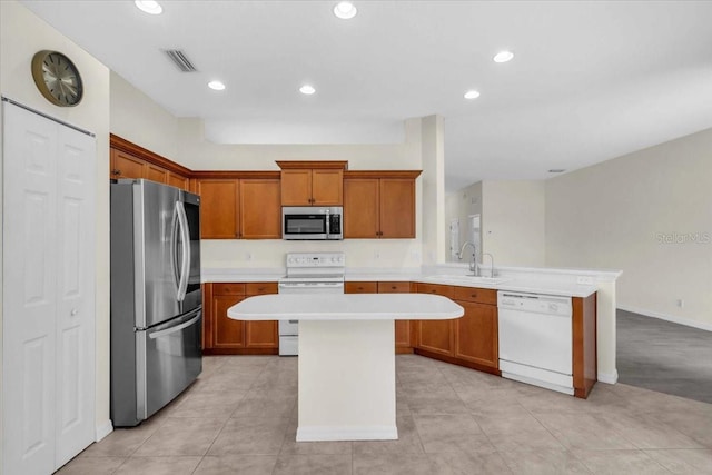 7026 43rd Ave E, Palmetto, FL 34221 - kitchen with stainless steel appliances, a peninsula, light countertops, brown cabinetry, and recessed lighting