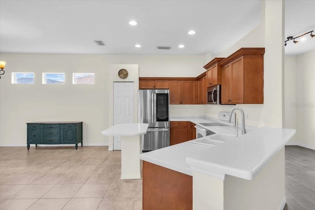 7026 43rd Ave E, Palmetto, FL 34221 - kitchen featuring stainless steel appliances, light countertops, brown cabinets, a peninsula, and recessed lighting