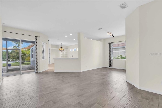 7026 43rd Ave E, Palmetto, FL 34221 - unfurnished living room with a chandelier, wood finished floors, and recessed lighting