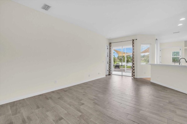 7026 43rd Ave E, Palmetto, FL 34221 - unfurnished living room featuring wood finished floors and recessed lighting