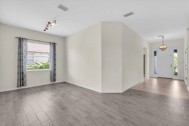 7026 43rd Ave E, Palmetto, FL 34221 - unfurnished room with a chandelier, wood finished floors, and rail lighting