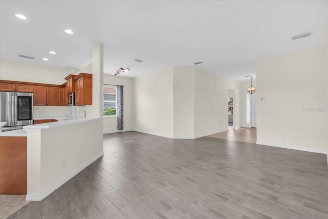 7026 43rd Ave E, Palmetto, FL 34221 - kitchen with appliances with stainless steel finishes, light countertops, open floor plan, light wood-style floors, and recessed lighting