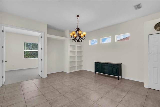 7026 43rd Ave E, Palmetto, FL 34221 - unfurnished room with light tile patterned flooring, a chandelier, and built in shelves