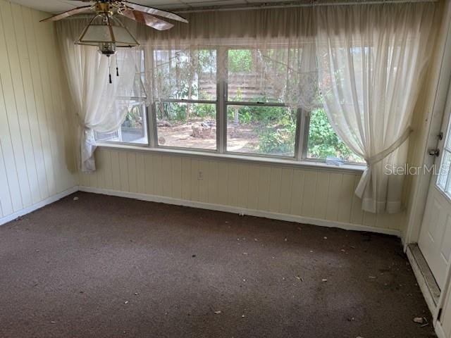 2451 Loma Linda St, Sarasota, FL 34239 - spare room featuring carpet, healthy amount of natural light, a ceiling fan, and wooden walls