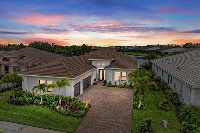 4915 Kiva Cir, Bradenton, FL 34211 - view of front of home featuring a garage, stucco siding, decorative driveway, and a tiled roof