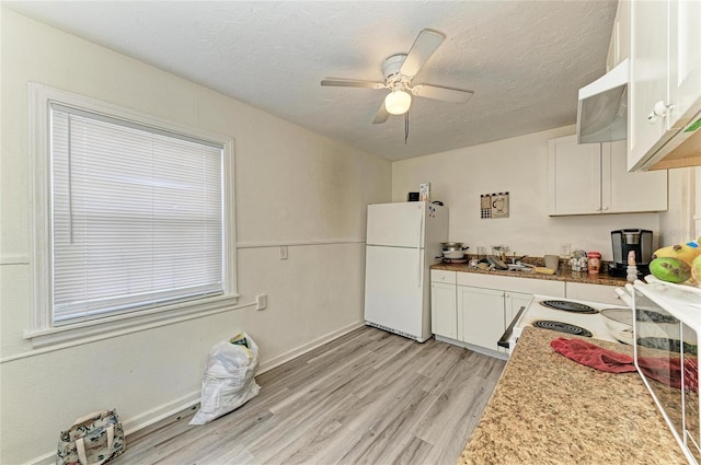 1701 13th St W, Bradenton, FL 34205 - kitchen with freestanding refrigerator, white cabinetry, light wood-style floors, ceiling fan, and a textured ceiling