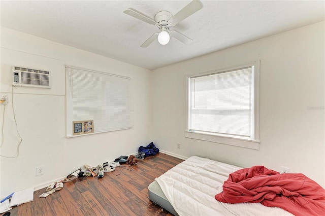 1701 13th St W, Bradenton, FL 34205 - bedroom featuring wood finished floors, a wall unit AC, and a ceiling fan