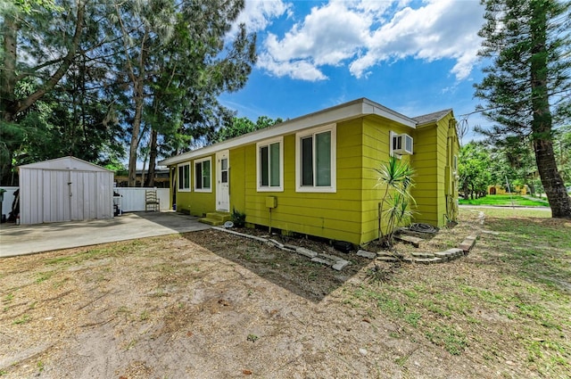 1701 13th St W, Bradenton, FL 34205 - view of front of property featuring a storage unit, a wall unit AC, a patio, and driveway