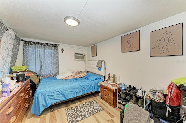 1701 13th St W, Bradenton, FL 34205 - bedroom with wood finished floors, an AC wall unit, and a textured ceiling