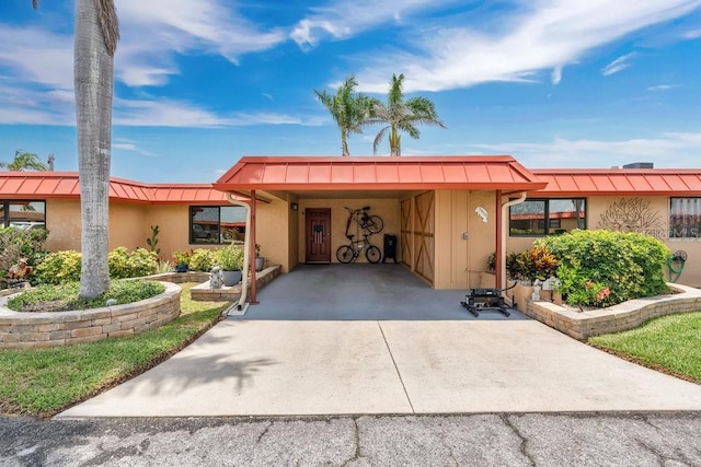 3850 Catalina Dr, Bradenton, FL 34210 - view of front facade with a standing seam roof, a metal roof, driveway, and a carport