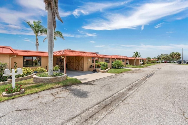 3850 Catalina Dr, Bradenton, FL 34210 - view of front of home featuring concrete driveway, a standing seam roof, a metal roof, and stucco siding
