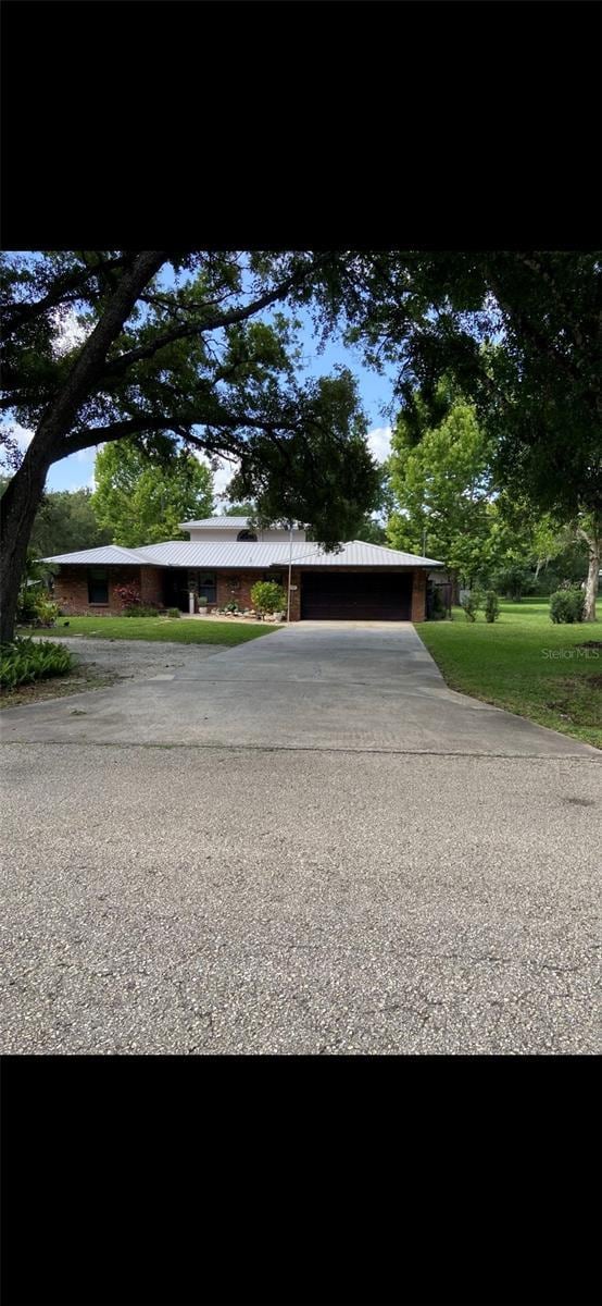 3683 Brown, Arcadia, FL 34266 - view of front of house with driveway, a carport, and a metal roof