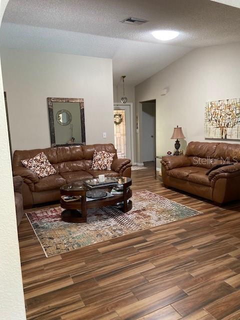 3683 Brown, Arcadia, FL 34266 - living room with vaulted ceiling, wood finished floors, arched walkways, and a textured ceiling