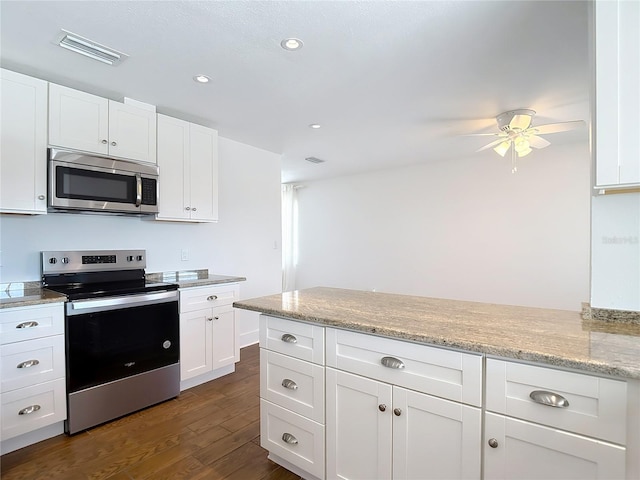 6341 Cocoa Ln, Apollo Beach, FL 33572 - kitchen with stainless steel appliances, dark wood finished floors, white cabinets, ceiling fan, and a peninsula