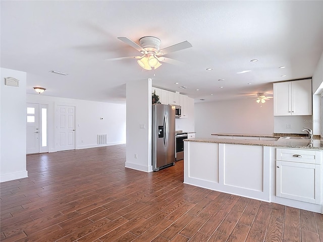 6341 Cocoa Ln, Apollo Beach, FL 33572 - kitchen with appliances with stainless steel finishes, ceiling fan, dark wood-style floors, open floor plan, and white cabinetry