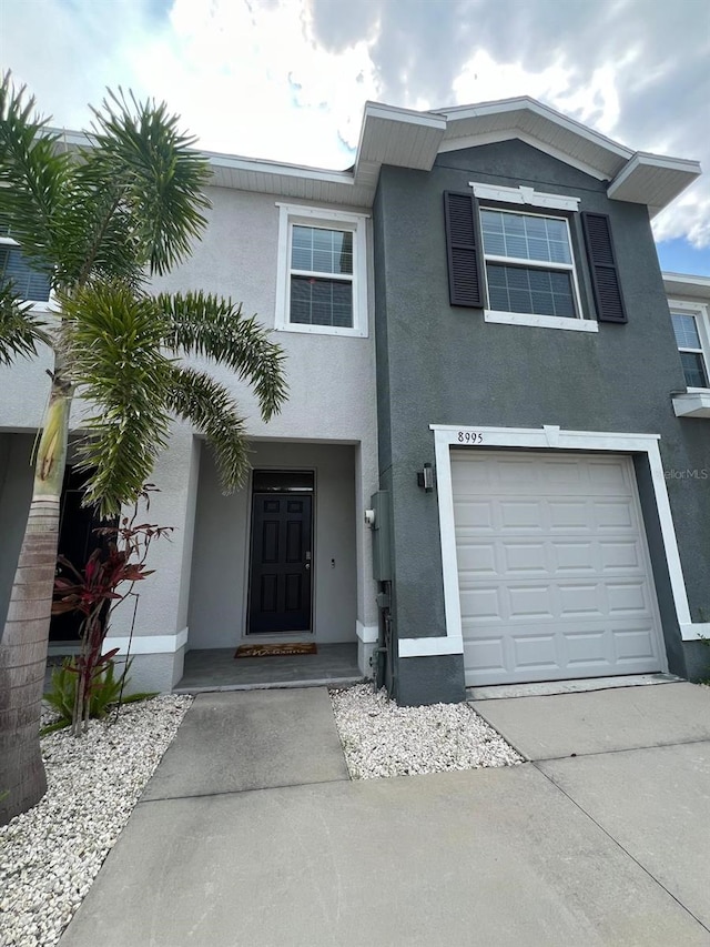 8995 Milestone Dr, Sarasota, FL 34238 - view of front of property featuring stucco siding, an attached garage, and concrete driveway