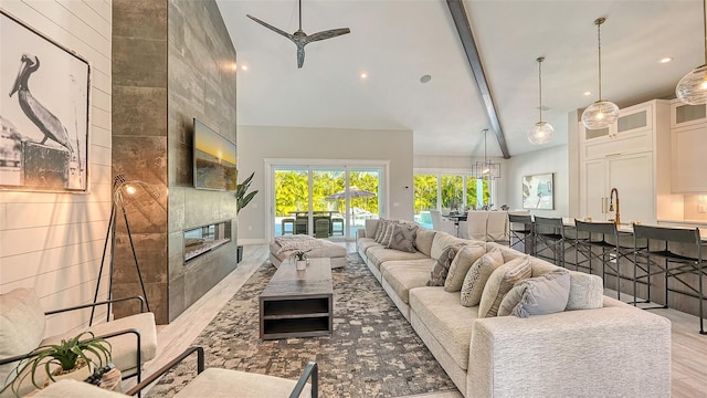 8006 20th Pl W, Bradenton, FL 34209 - living room featuring wood finished floors, high vaulted ceiling, a fireplace, beam ceiling, and a ceiling fan