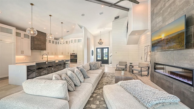 8006 20th Pl W, Bradenton, FL 34209 - living area featuring high vaulted ceiling, a tile fireplace, and light wood finished floors