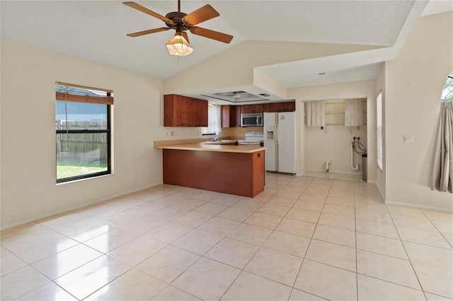4805 Cypress Lake Ct, Sarasota, FL 34243 - kitchen featuring white appliances, a peninsula, vaulted ceiling, light countertops, and light tile patterned floors