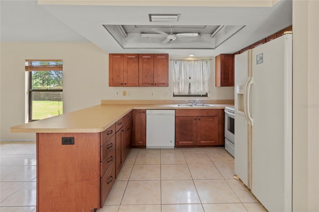 4805 Cypress Lake Ct, Sarasota, FL 34243 - kitchen with white appliances, a peninsula, a raised ceiling, light tile patterned floors, and light countertops